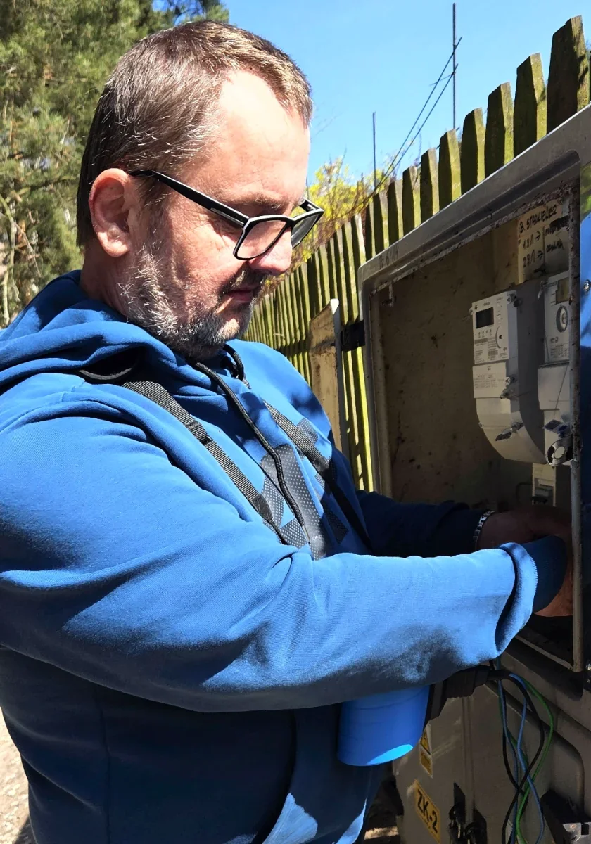 Krzysztof Zamarja, właściciel EFV WELPOL, podczas pomiaru instalacji przy szafce licznikowej