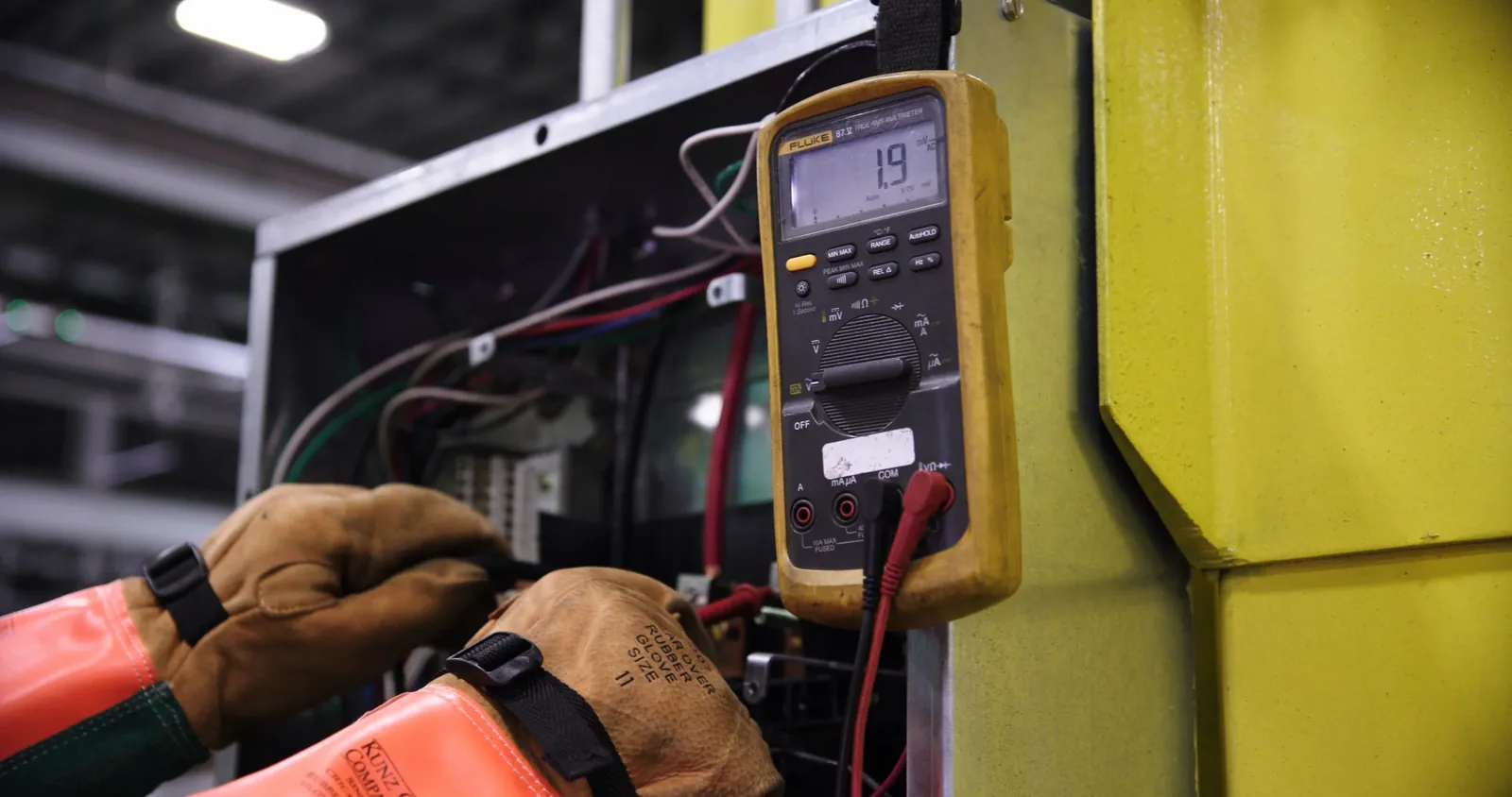 Inspektor wykonuje pomiary instalacji elektrycznej miernikiem przy rozdzielnicy